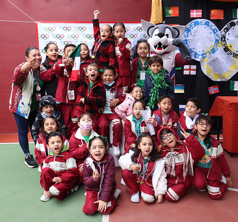 Fotografía de niños de preescolar junto con Lofito en el podium en el evento de las mini olimpiadas 