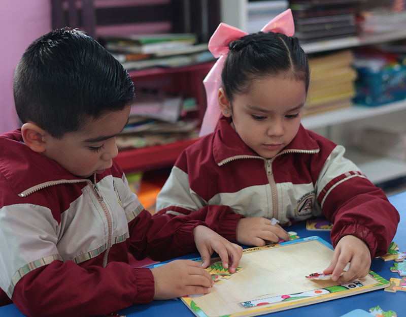 Estudiantes de nivel preescolar del Colegio Oliverio Cromwell armando un rompecabezas en equipo