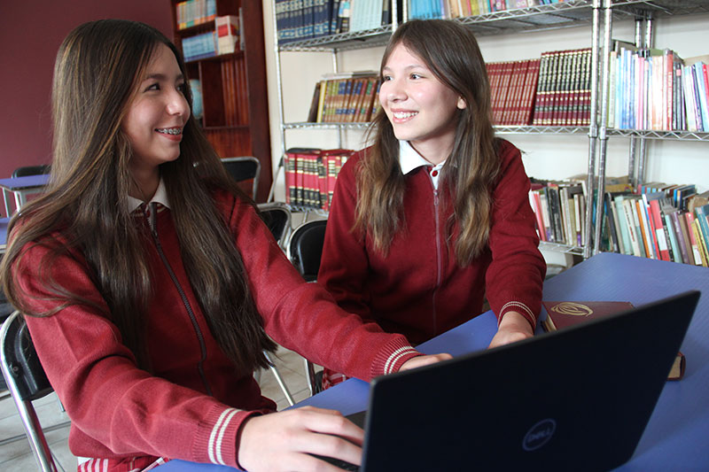 Estudiantes del Colegio Oliverio Cromwell Nivel Secundaria en las instalaciones de la biblioteca estudiando en equipo 