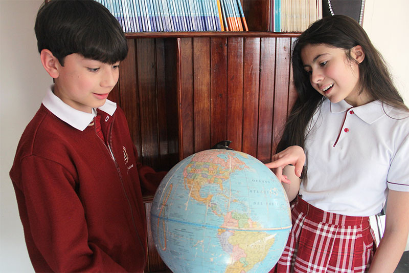 Estudiantes del Colegio Oliverio Cromwell Nivel Secundaria aprendiendo sobre geografía en un globo terráqueo