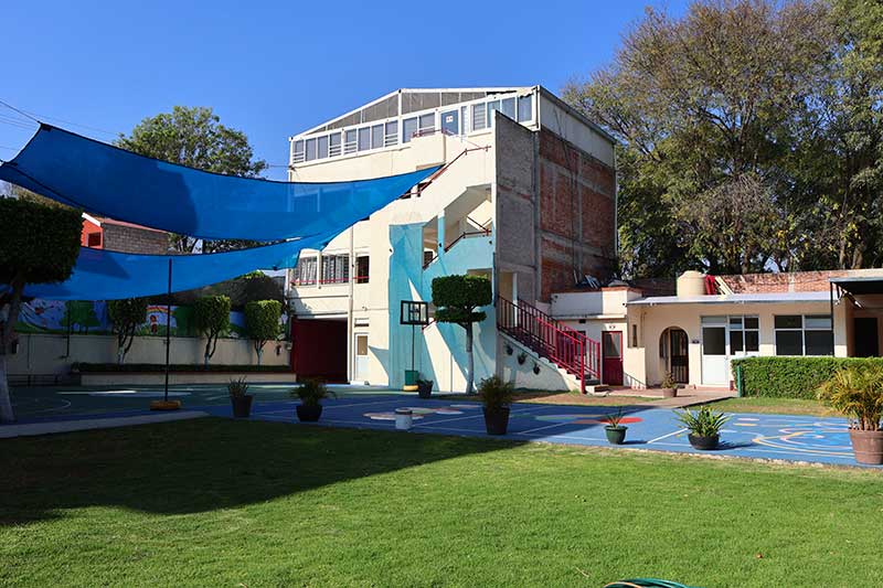Fotografía de áreas verdes y edificio del nivel primaria del plantel Xochimilco del Coelgio Oliverio Cromwell